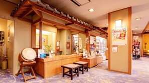 A reception area with a wooden counter, a drum, and a small table.