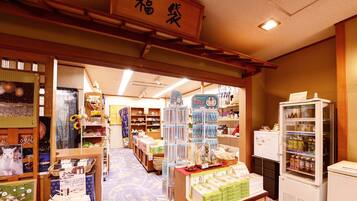 A traditional Japanese store interior with wooden shelves, a display counter, and a refrigerated section.