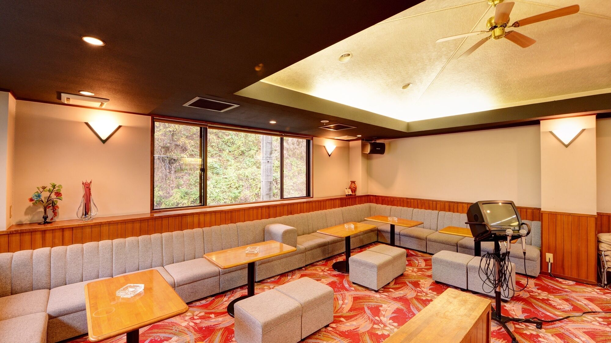 A room with a sofa, tables, a ceiling fan, and a projector.