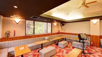 A room with a sofa, tables, a ceiling fan, and a projector.