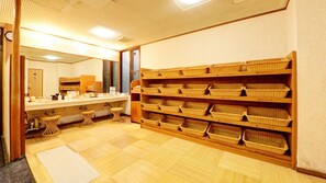 Une salle de bain avec un lavabo, un miroir et des étagères avec des paniers.