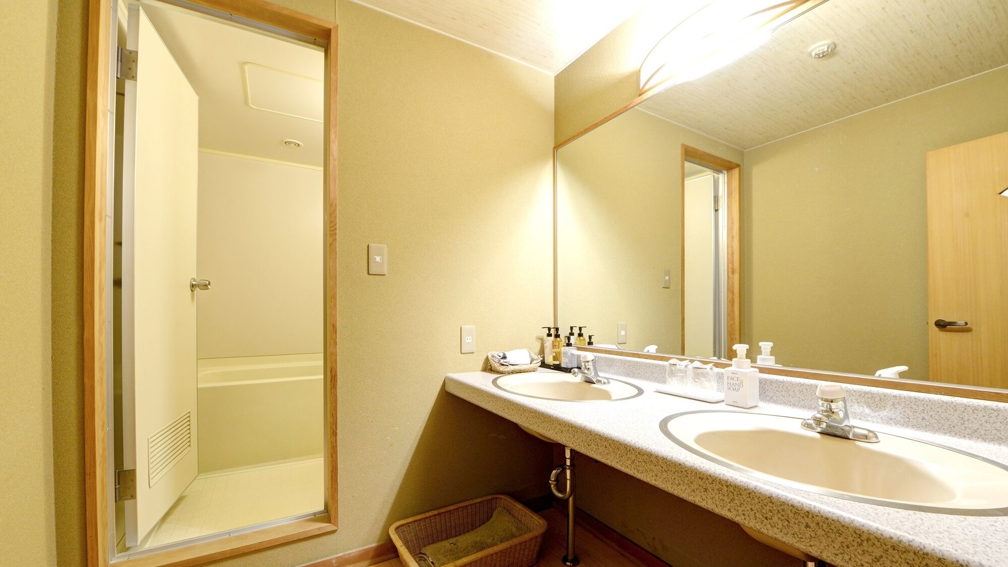 Un baño con dos lavamanos, un espejo grande y una ducha.