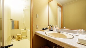 Un baño con lavamanos, espejo y artículos de aseo.