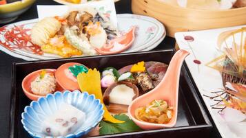 A traditional Japanese meal with various dishes in separate bowls and a wooden tray.