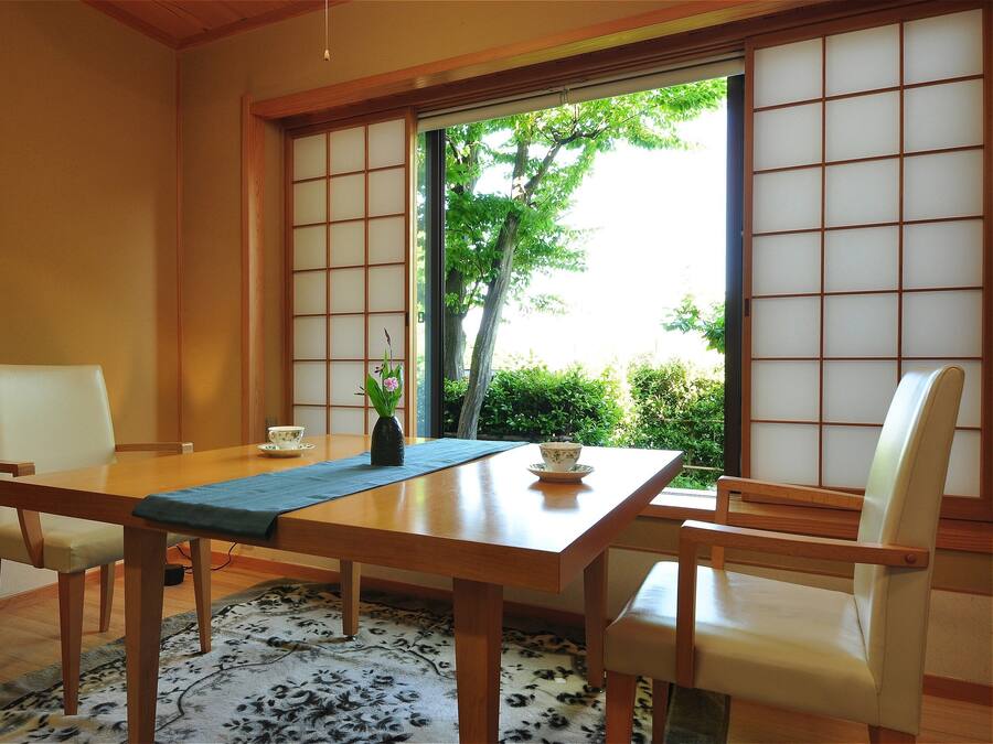 Une pièce de style japonais traditionnel, avec un sol recouvert de tatamis, une table basse et des paravents en papier.