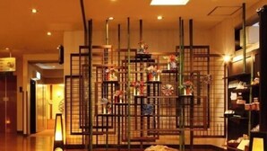 Eine Hotelhalle mit Holzboden, einer Rezeption und einer Wand mit Regalen.