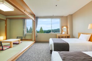 Une chambre d’hôtel comprenant un lit, un bureau, une chaise, une fenêtre donnant sur des arbres et un sol recouvert de moquette.