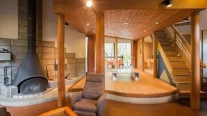Amplia sala de estar con chimenea, un área de descanso cómoda y una escalera que sube a otro nivel.