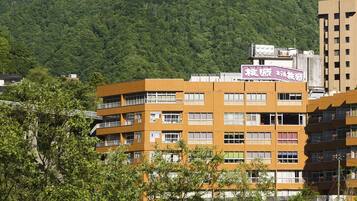 A multi-story building with a flat roof and a sign in a foreign language.
