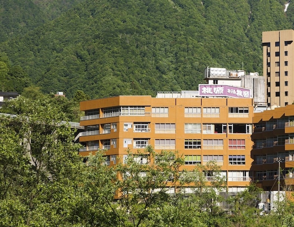 A multi-story building with a flat roof and a sign in a foreign language.
