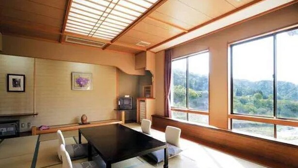 A traditional Japanese-style room with tatami flooring, a low table, and a television. - Sasakura Onsen Ryuunso (Itoigawa)