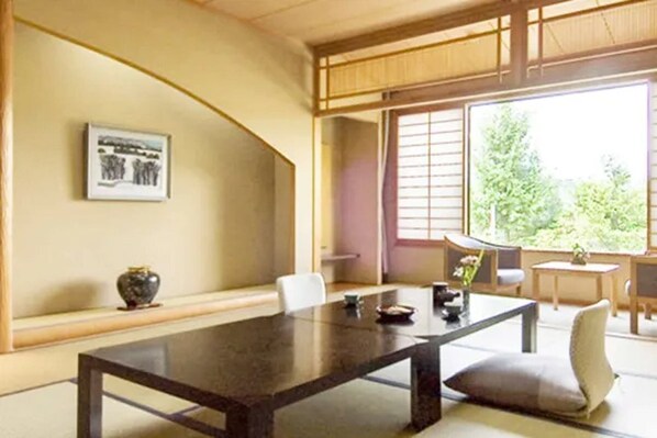 Una habitación japonesa tradicional con suelo de tatami, una mesa baja y una puerta corredera.