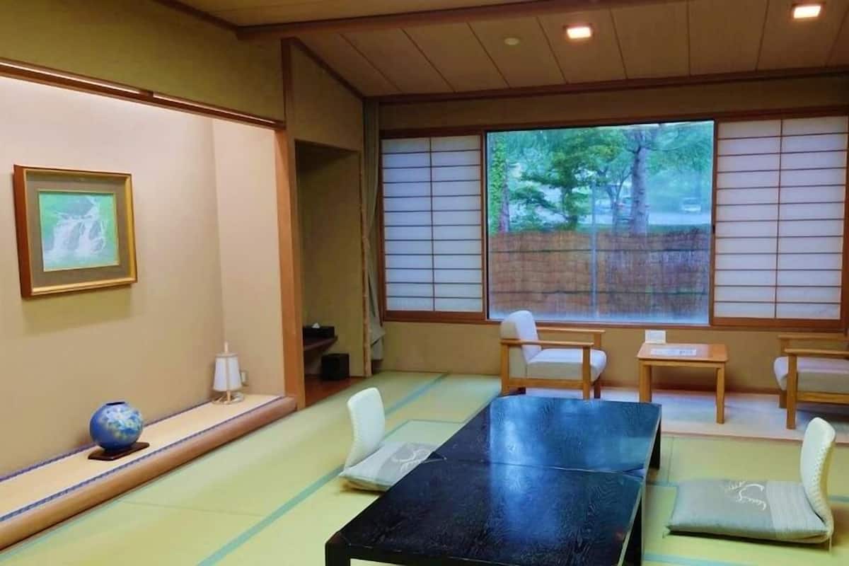 Perinteinen japanilainen huone, jossa on tatamimatto, matala pöytä ja liukuvat ovet.