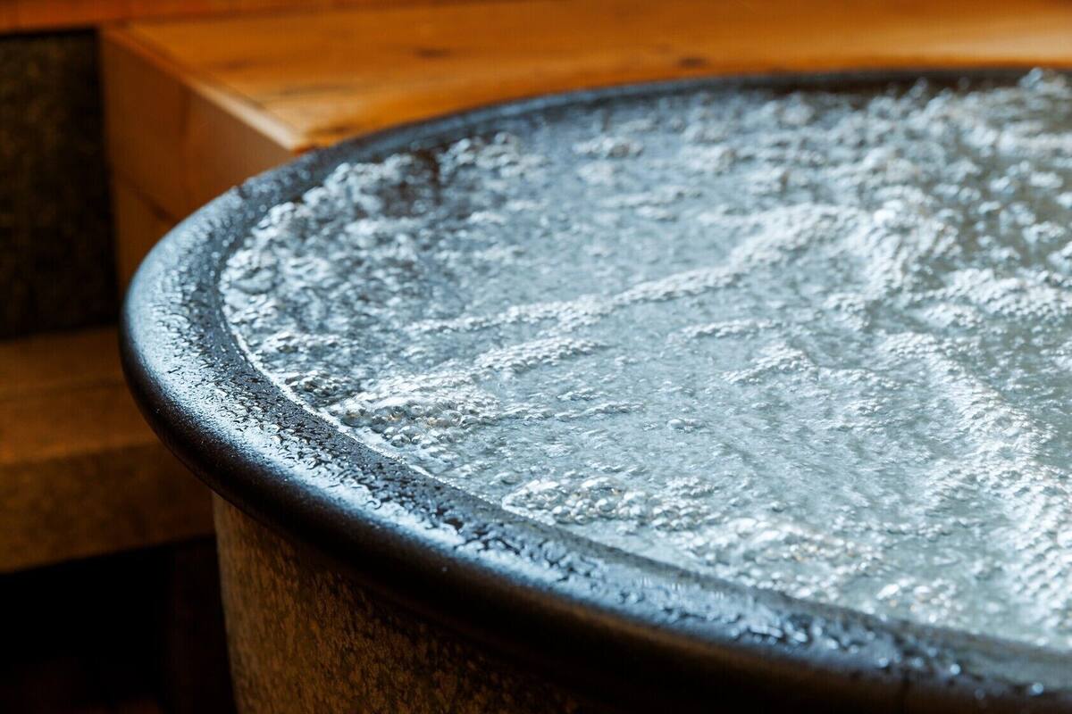 A close-up of a metallic surface with water droplets, likely part of a pool or water feature.