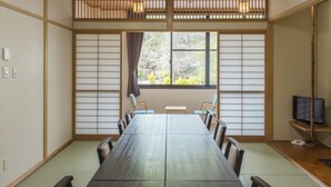 A traditional Japanese-style meeting room with tatami flooring, a long wooden table, and shoji screens. - Sugatani Onsen (Nagahama)