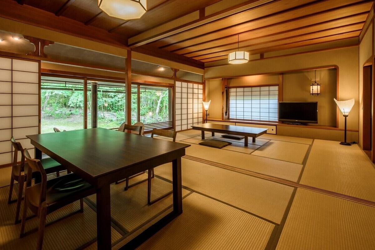 A traditional Japanese room with tatami flooring, a low table, and a television.