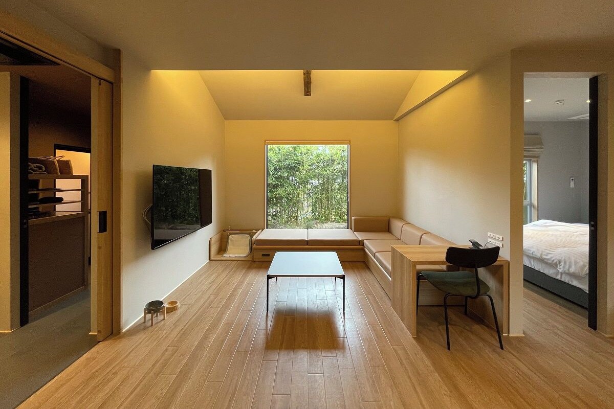 A modern interior with a sofa, a table, and a TV mounted on the wall.