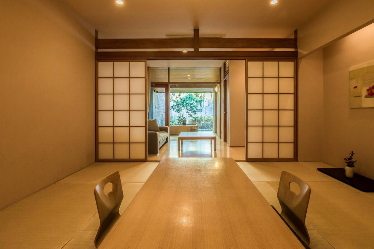A traditional Japanese-style room with tatami flooring, a low table, and sliding doors.
