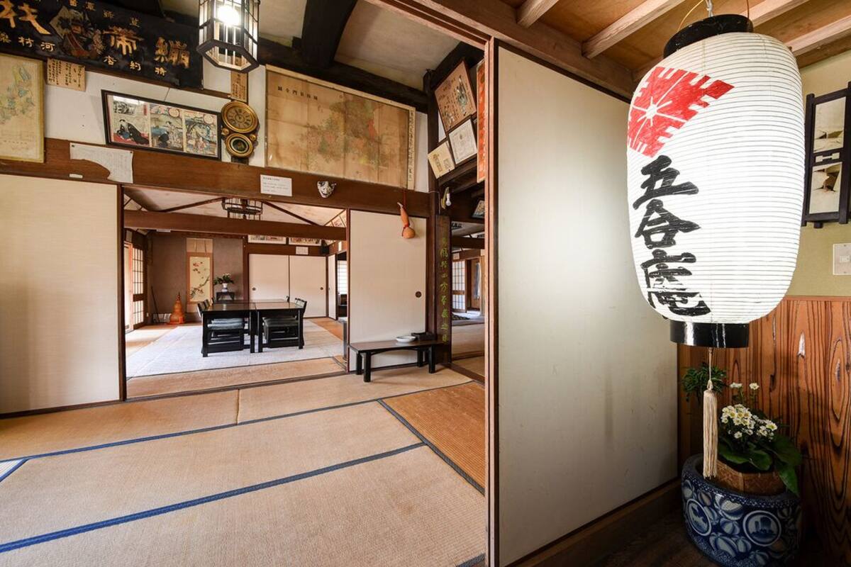 A traditional Japanese room with tatami flooring, a shoji screen, and a hanging lantern.