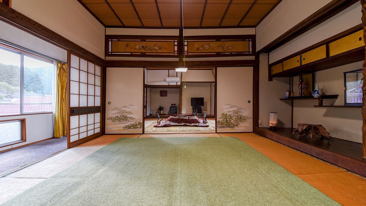 Une pièce de style japonais traditionnel, avec un sol recouvert de tatamis, des portes coulissantes et une vue à travers un paravent en papier washi.