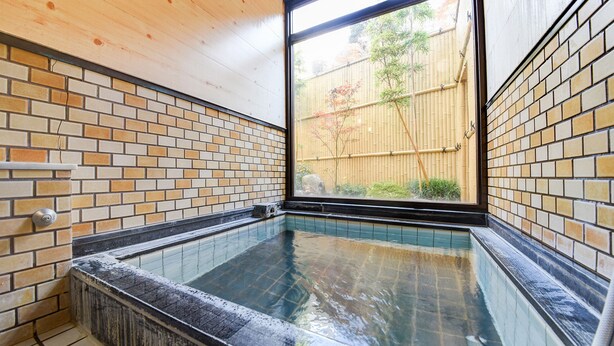 A hot tub with tiled walls and a window overlooking a bamboo fence. - Yamaguchiya Annex (Nagato)
