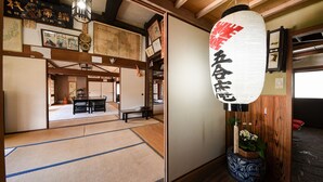 A traditional Japanese room with tatami flooring, a shoji screen door, and a hanging lantern. - Yamaguchiya Annex (Nagato)