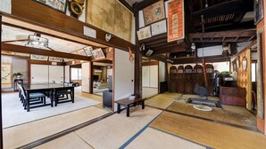 A traditional Japanese room with tatami flooring, a low table, and sliding doors. - Yamaguchiya Annex (Nagato)