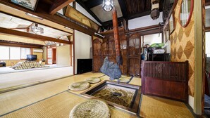 A traditional Japanese room with tatami flooring, a fish sculpture, and a wooden cabinet. - Yamaguchiya Annex (Nagato)