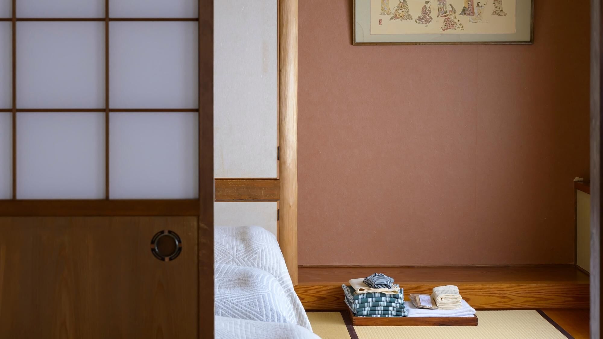 Perinteinen japanilainen huone, jossa on tatamimatto, shoji-liukuovi ja futon-patja.