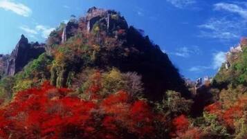 Paisagem montanhosa com um pico imponente e vegetação densa.