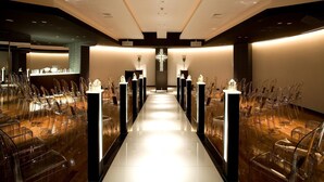A modern hotel lobby with a central aisle, clear chairs on either side, and a reception desk at the end. - Grand Plaza Nakatsu Hotel (Nakatsu)