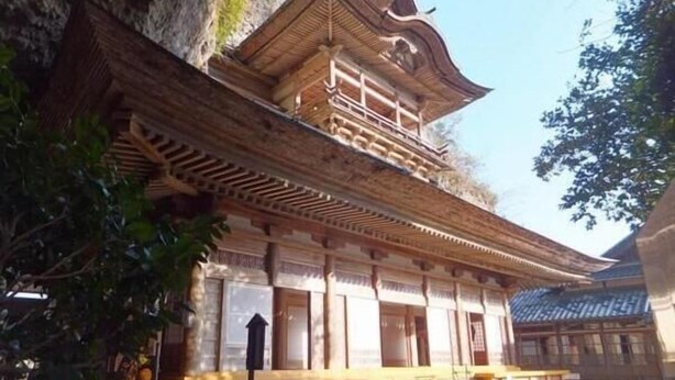 A traditional wooden building with a balcony, large windows, and a stone wall. - Grand Plaza Nakatsu Hotel (Nakatsu)