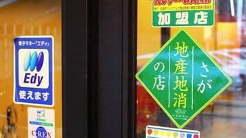 A hotel window with various stickers, including one for Edy, a sign for Thunder & Colt Euro-Center, and a green sign with Japanese text.