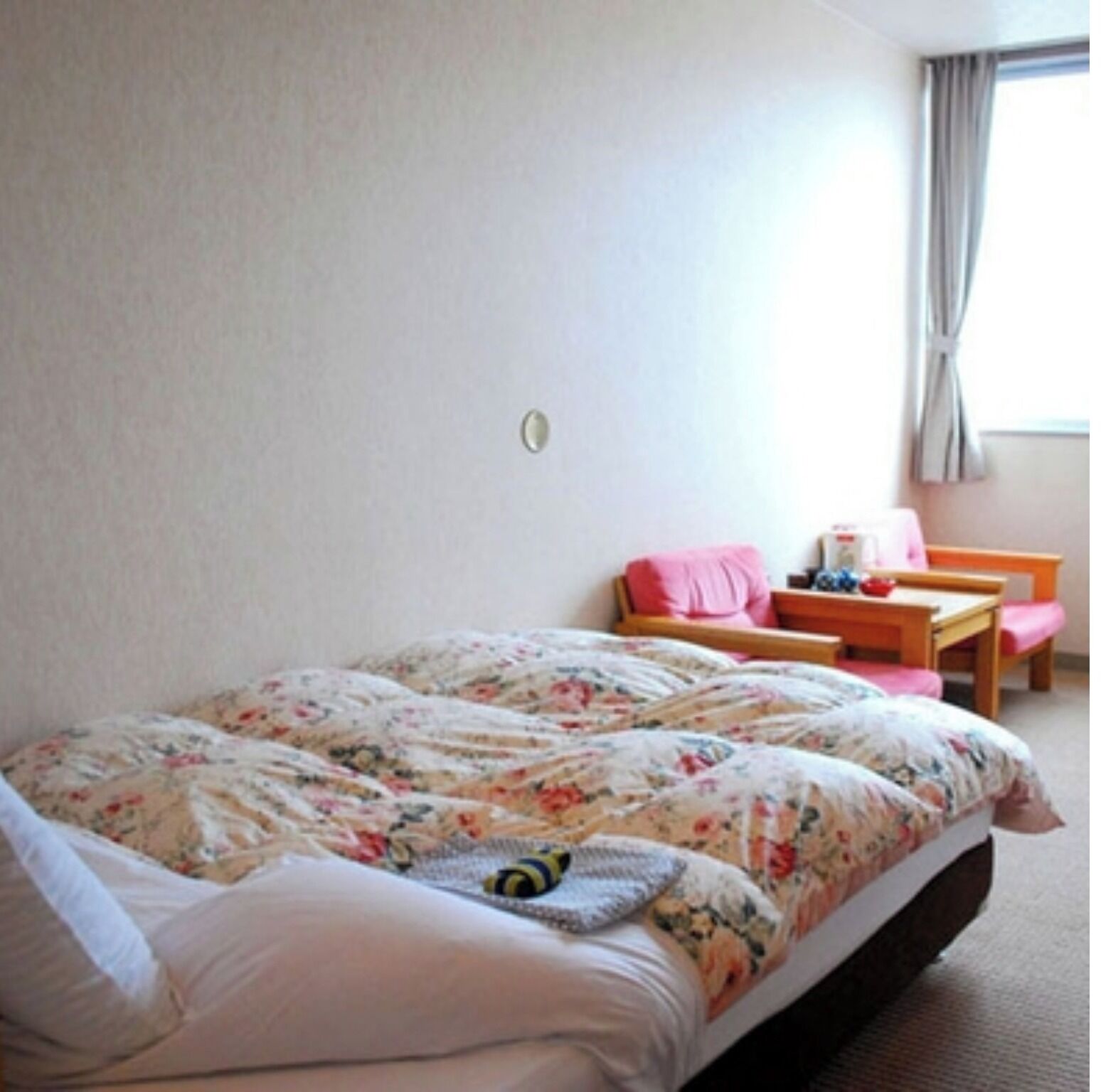 Une chambre à coucher avec un lit, une chaise, une table et une fenêtre.