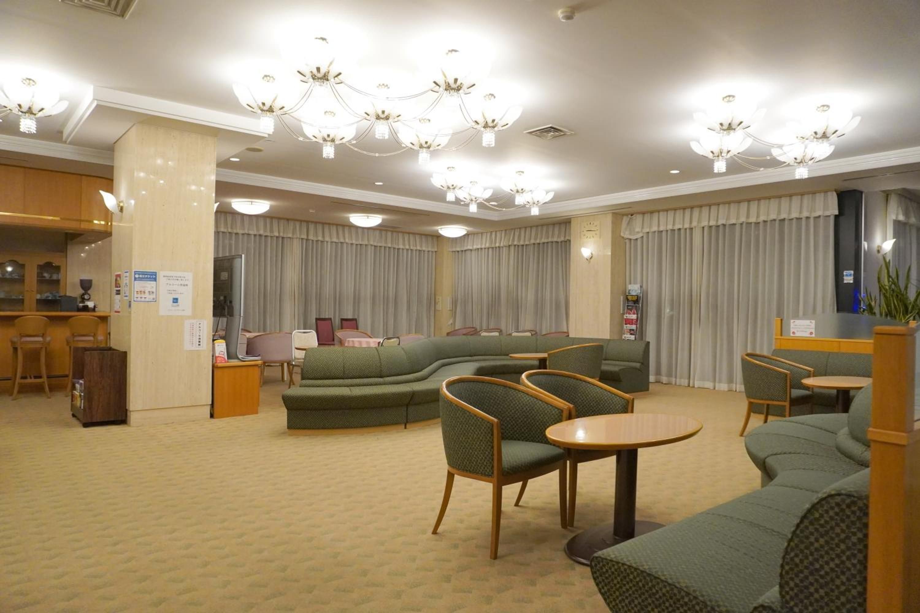 A hotel lobby with a seating area, a bar, and a reception desk.