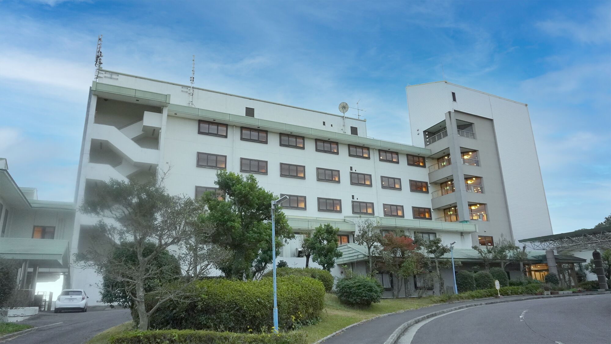 A multi-story hotel with a modern design, featuring a flat roof and a mix of window styles.