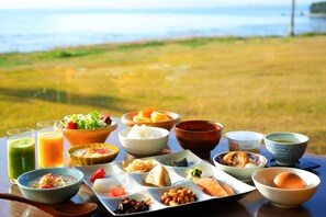 A table with various dishes and drinks, set against a scenic outdoor background. - Spa & Resort HOTEL SOLAGE OITA・HIJI Beppuwan (Hiji)