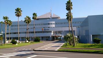 A modern hotel with a flat roof, multiple floors, and a prominent entrance.