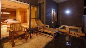 Une terrasse en bois avec un jacuzzi, des chaises longues et une petite table.