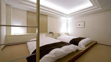 Habitación de hotel con cama, mesita de noche, espejo y luz de techo.
