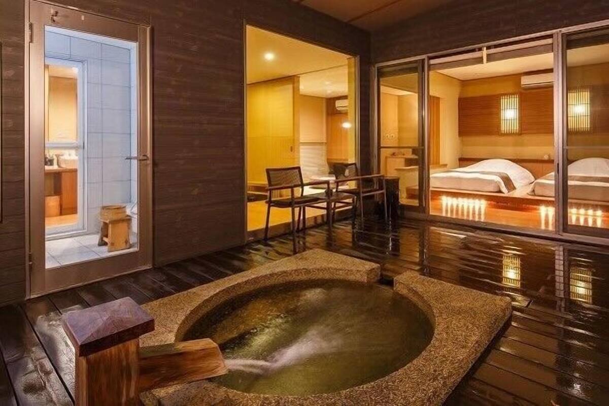 Une chambre d’hôtel moderne dotée d’un jacuzzi, d’un coin repas et d’un grand lit avec vue.