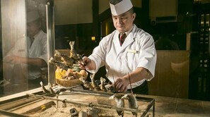 A chef in a white uniform preparing food in a kitchen. - Okuyado Buaisou (Yufu)