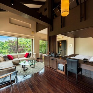 A modern hotel room with a large window, a sofa, a dining area, and a kitchen counter. - Okuyado Buaisou (Yufu)