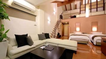 Una sala de estar moderna con un sofá, una mesa de centro y una escalera que conduce a un dormitorio tipo loft.