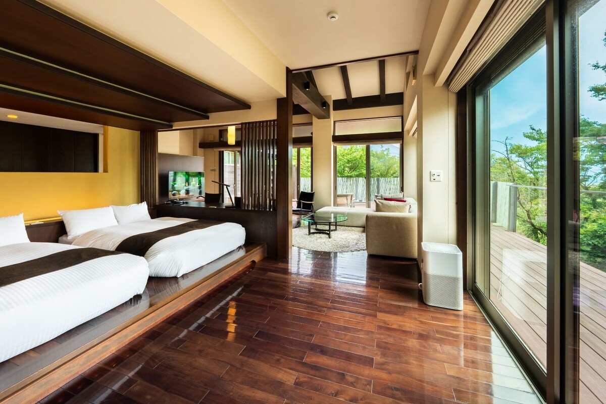Una habitación de hotel moderna con una cama grande, un televisor y vistas al exterior.