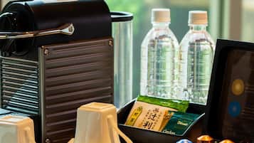 A coffee maker, two water bottles, a tea set, and a menu on a table.