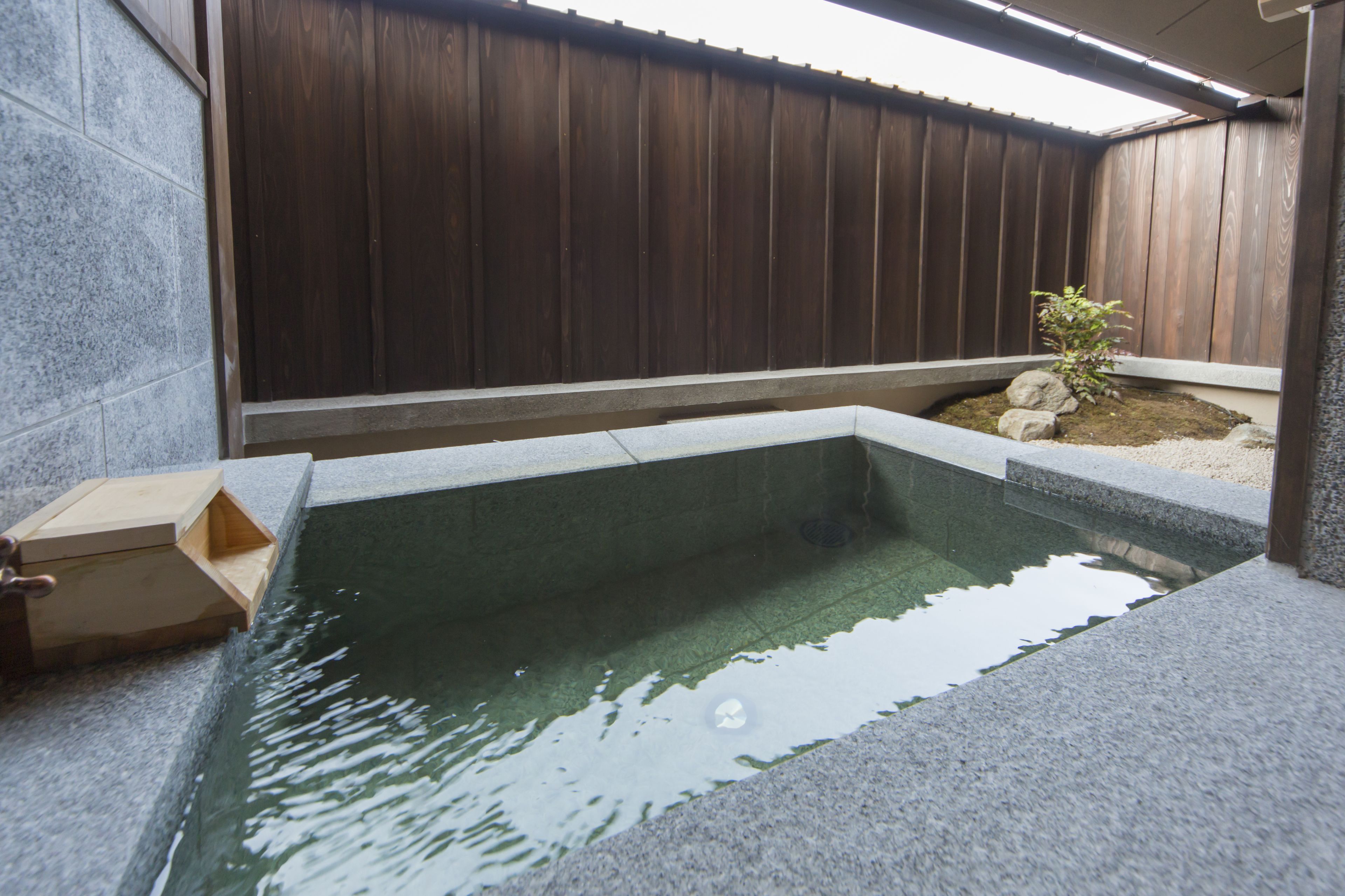 A rectangular pool with a wooden fence in the background.