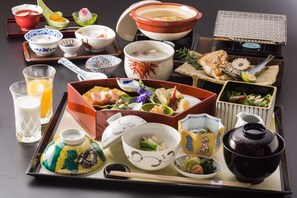 A variety of traditional Japanese dishes and utensils on a tray, including bowls, a teapot, and chopsticks. - Inisienoyado Keiunn (Izumo)