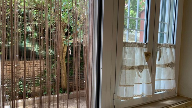 Una habitación con ventana que da a un jardín.