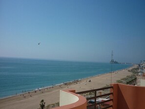 Una spiaggia con vista libera sul mare e una città in lontananza.